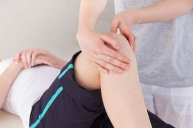 Masaje terapéutico en rodillas para aliviar síntomas de artritis y mejorar la movilidad en pacientes.
